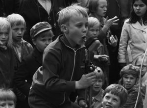 Kallio Torkkelinmäki Karhupuisto Helsingin juhlaviikot. Poika laulamassa mikrofoniin puistotapahtuman aikaan Karhupuistossa.